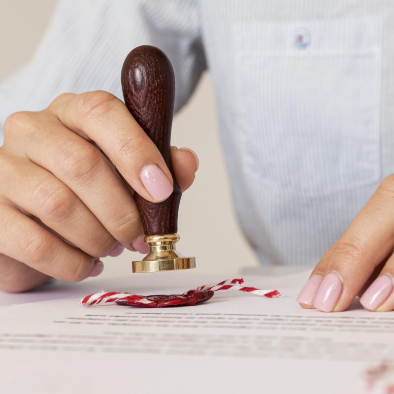 person-using-wax-seal-blurred-certificate person-using-wax-seal-blurred-certificate